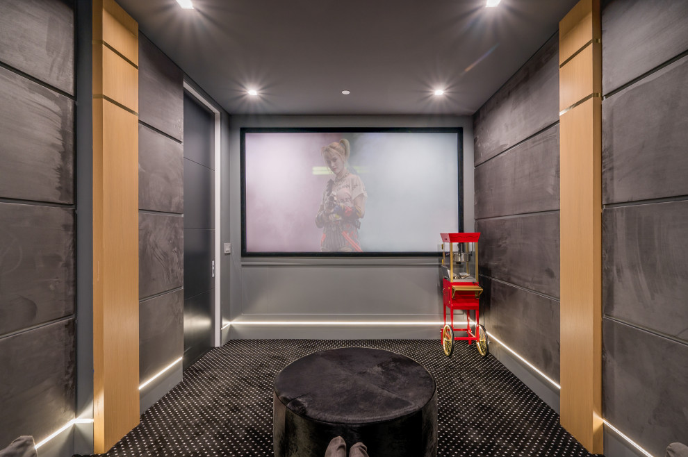 Photo of a mid-sized modern enclosed home theatre in Los Angeles with grey walls, carpet, a projector screen and black floor.