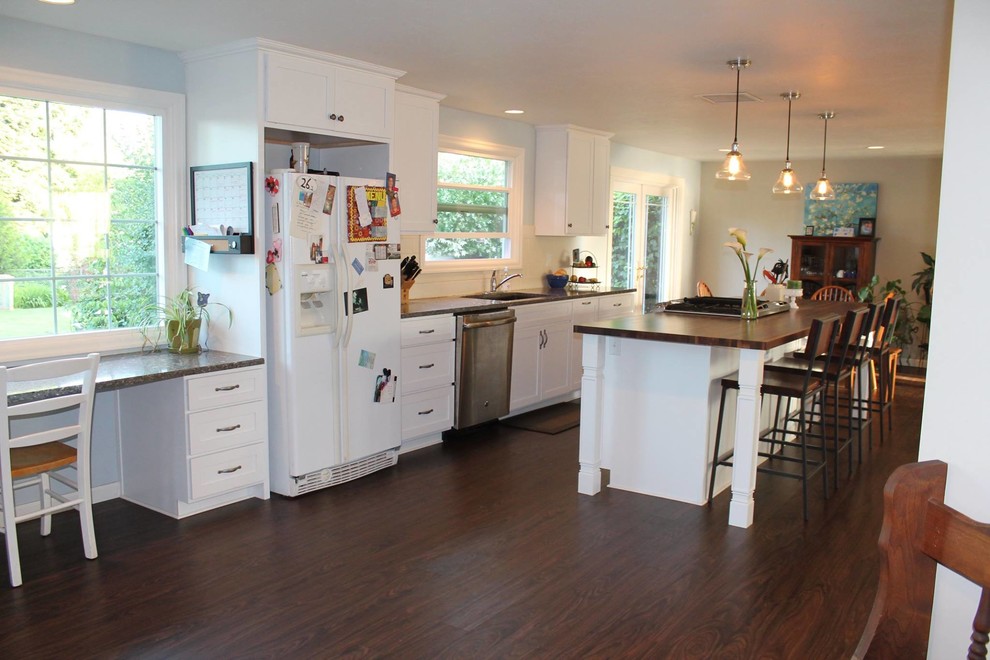 Open concept kitchen - mid-sized transitional galley dark wood floor and brown floor open concept kitchen idea with an undermount sink, shaker cabinets, white cabinets, wood countertops, white backsplash, porcelain backsplash, white appliances and an island