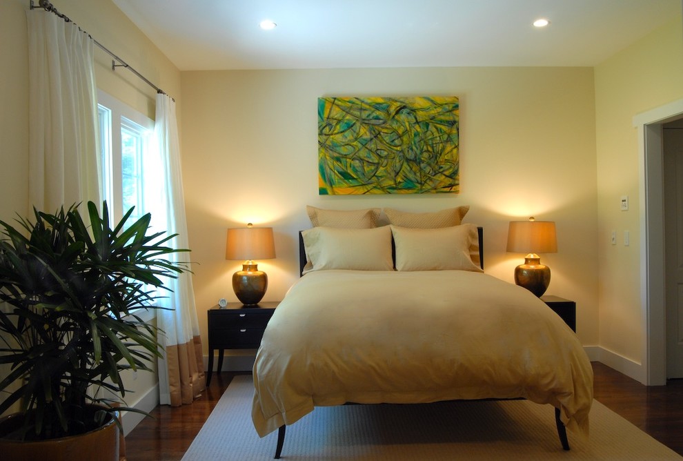 Inspiration for a mid-sized modern master bedroom in Orange County with yellow walls, dark hardwood floors and brown floor.