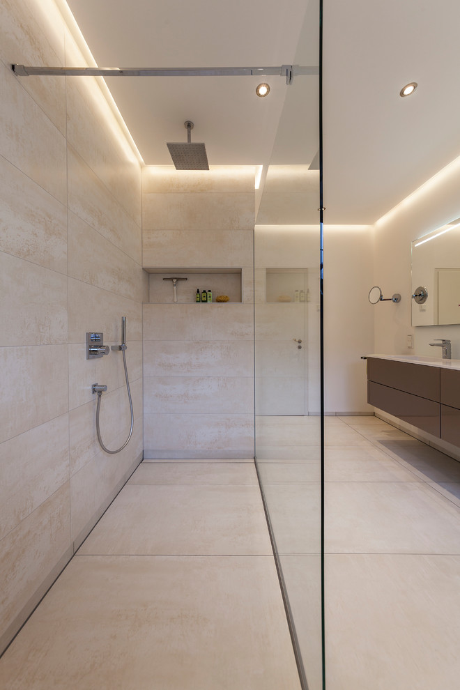 Design ideas for a medium sized contemporary shower room bathroom in Cologne with flat-panel cabinets, brown cabinets, a built-in shower, a two-piece toilet, beige tiles, stone tiles, beige walls, an integrated sink, solid surface worktops, beige floors and an open shower.