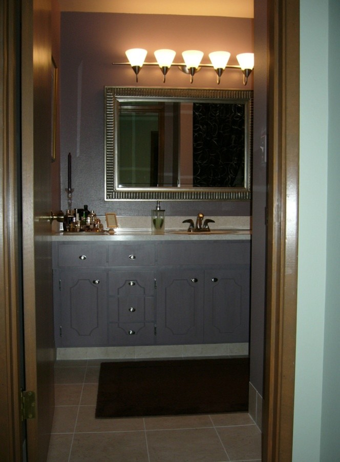Photo of a mid-sized transitional bathroom in Seattle with recessed-panel cabinets, medium wood cabinets, laminate benchtops, a drop-in tub, beige tile, matchstick tile and purple walls.