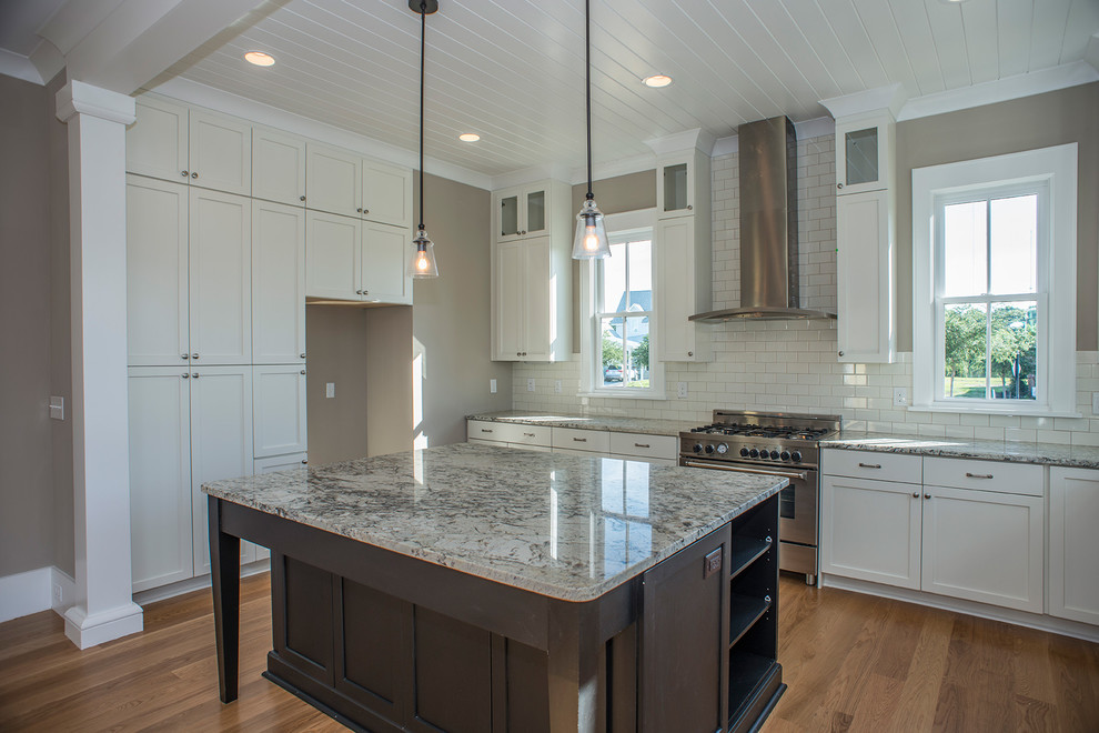 Inspiration for a transitional l-shaped eat-in kitchen in Charleston with an undermount sink, recessed-panel cabinets, white cabinets, granite benchtops, yellow splashback, ceramic splashback, stainless steel appliances, medium hardwood floors and with island.