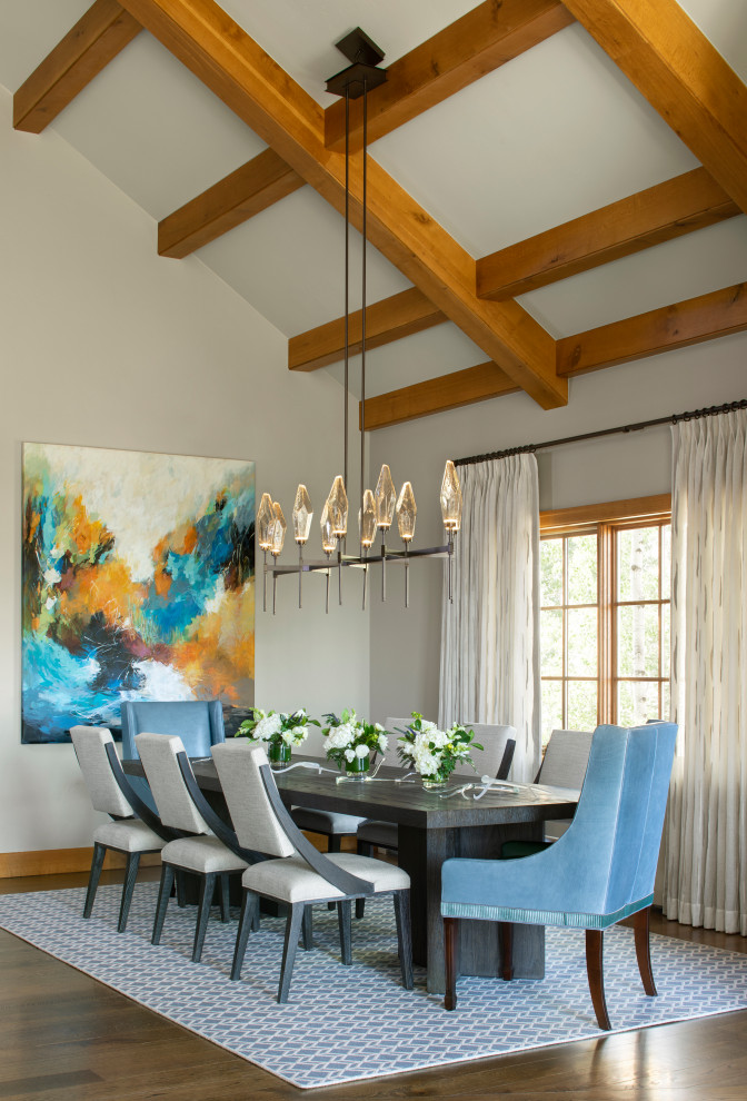 This is an example of a large country dining room in Denver with grey walls, medium hardwood floors, brown floor and exposed beam.