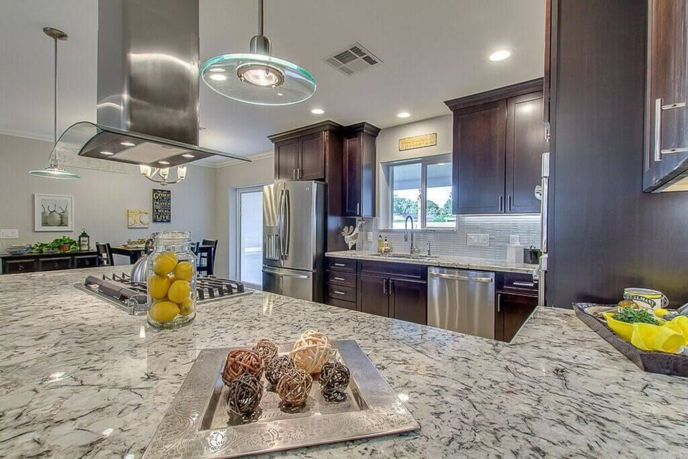 Inspiration for a large transitional u-shaped porcelain tile and beige floor eat-in kitchen remodel in Phoenix with a double-bowl sink, dark wood cabinets, shaker cabinets, granite countertops, gray backsplash, glass tile backsplash, stainless steel appliances and a peninsula