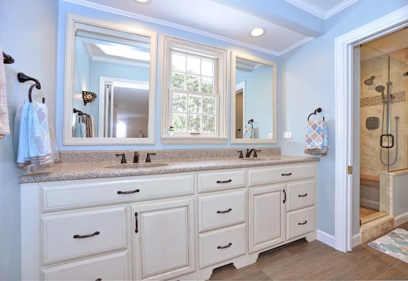 Doorless shower - mid-sized transitional master medium tone wood floor doorless shower idea with recessed-panel cabinets, medium tone wood cabinets, a two-piece toilet, green walls, a drop-in sink and granite countertops