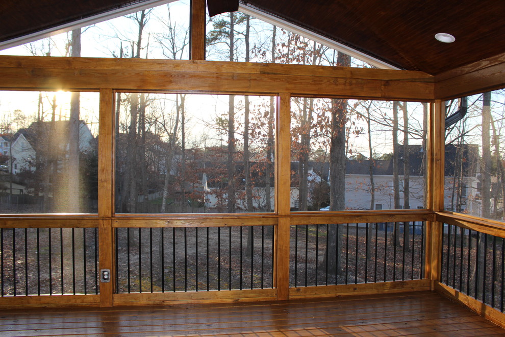 This is an example of a mid-sized country backyard screened-in verandah in Raleigh with decking.
