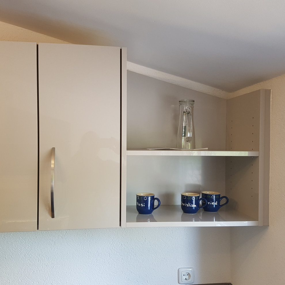 Photo of a medium sized modern u-shaped enclosed kitchen in Nuremberg with a double-bowl sink, flat-panel cabinets, beige cabinets, grey splashback, stainless steel appliances, concrete flooring, grey floors and grey worktops.