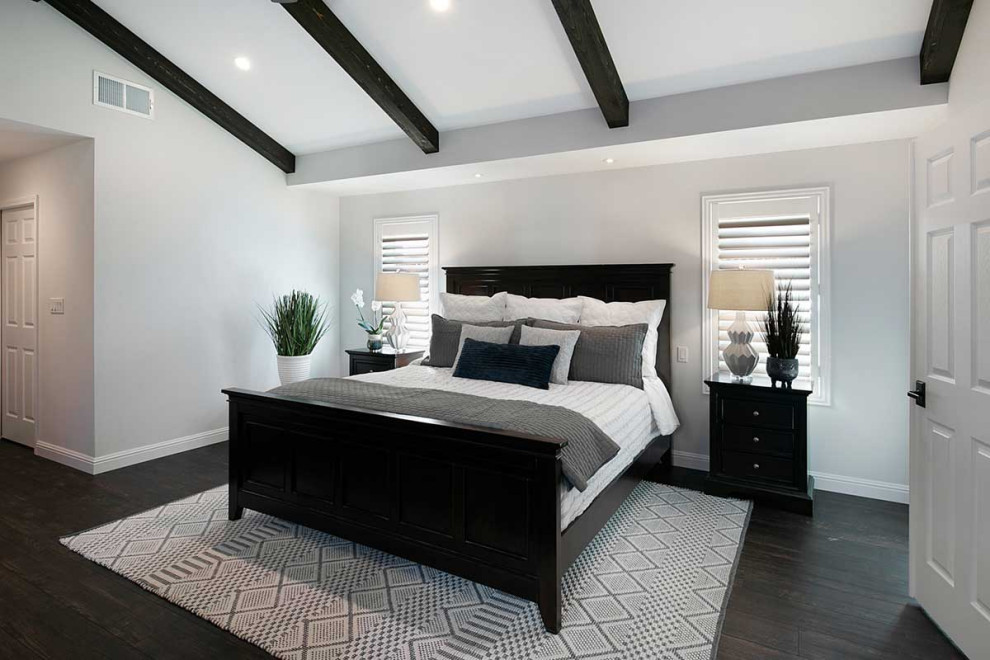 Стильный дизайн: большая хозяйская спальня в стиле неоклассика (современная классика) с серыми стенами, темным паркетным полом, черным полом, балками на потолке, стандартным камином и фасадом камина из металла - последний тренд