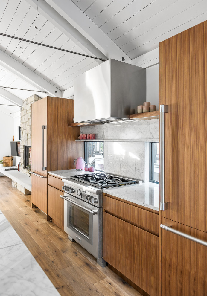 Design ideas for a mid-sized contemporary galley eat-in kitchen in Vancouver with medium wood cabinets, panelled appliances, medium hardwood floors, with island, brown floor, flat-panel cabinets, quartzite benchtops, white splashback, marble splashback and white benchtop.