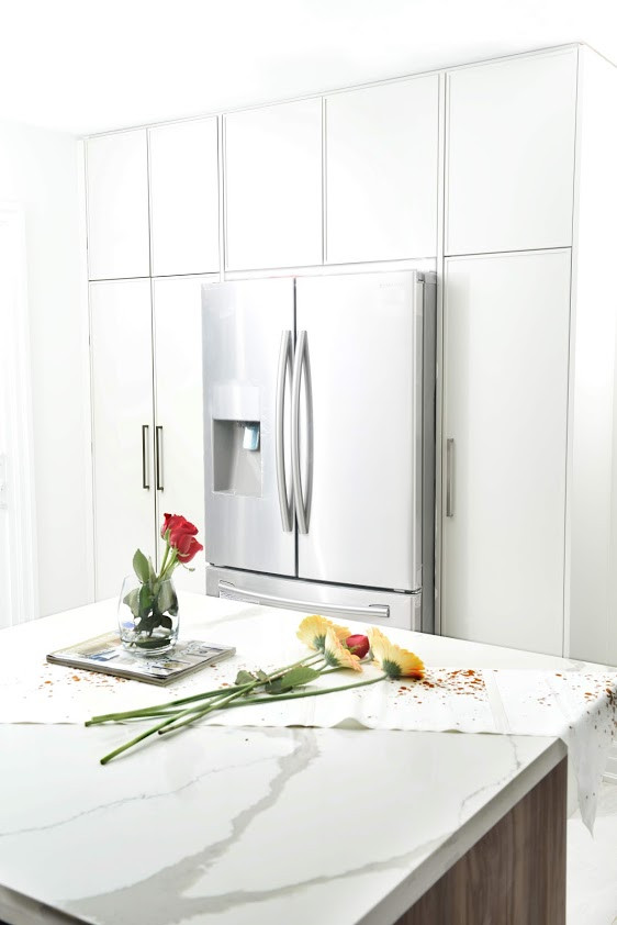Open concept kitchen - mid-sized u-shaped light wood floor and white floor open concept kitchen idea with an undermount sink, shaker cabinets, gray cabinets, quartzite countertops, white backsplash, metal backsplash, stainless steel appliances, an island and white countertops