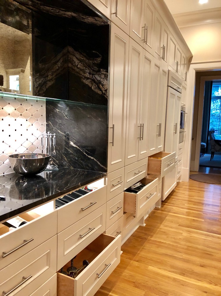 Inspiration for a mid-sized transitional single-wall eat-in kitchen in Atlanta with beaded inset cabinets, white cabinets, granite benchtops, white splashback, mosaic tile splashback, panelled appliances, light hardwood floors and brown benchtop.