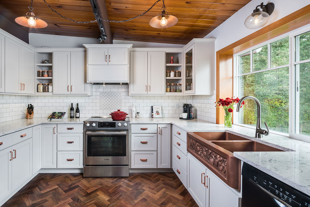 This is an example of a mid-sized country u-shaped kitchen in Other with a farmhouse sink, shaker cabinets, white splashback and subway tile splashback.