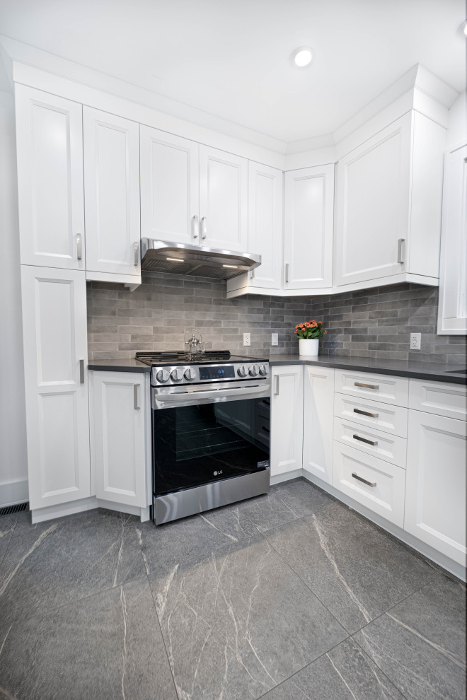 Inspiration for a mid-sized transitional galley enclosed kitchen remodel with an undermount sink, shaker cabinets, white cabinets, quartz countertops, gray backsplash, subway tile backsplash, stainless steel appliances, no island and gray countertops