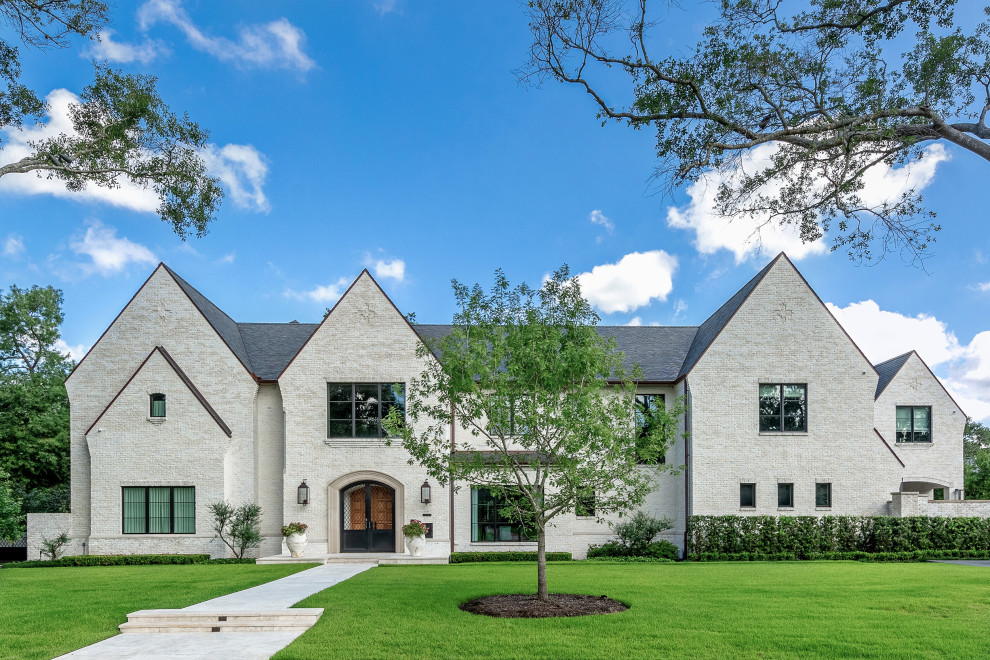 Großes, Zweistöckiges Klassisches Einfamilienhaus mit Backsteinfassade, beiger Fassadenfarbe, Satteldach, Schindeldach und grauem Dach in Houston