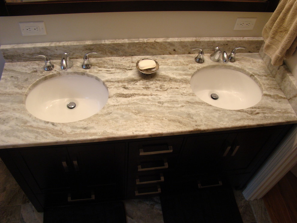 This is an example of a mid-sized transitional master bathroom in New York with an undermount sink, recessed-panel cabinets, dark wood cabinets, marble benchtops, a corner shower, a one-piece toilet and beige walls.