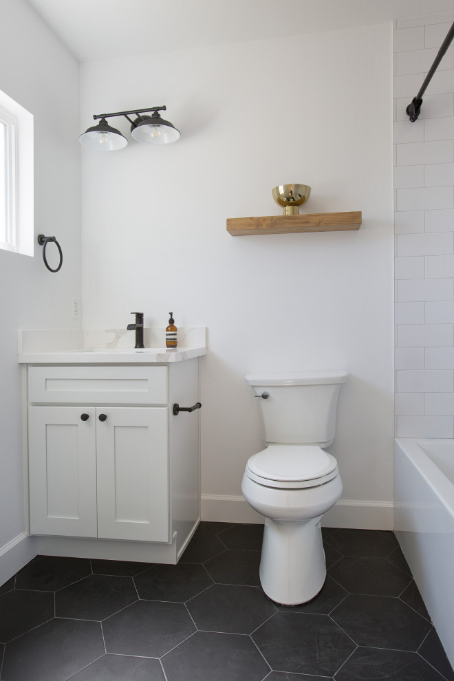 Photo of a mid-sized transitional kids bathroom in Los Angeles with beaded inset cabinets, white cabinets, an alcove tub, a shower/bathtub combo, a one-piece toilet, white tile, white walls, laminate floors, an undermount sink, engineered quartz benchtops, a shower curtain, white benchtops, a double vanity, a built-in vanity and black floor.