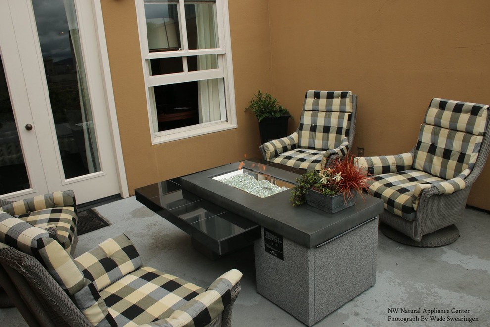 This is an example of a mid-sized contemporary backyard patio in Portland with a fire feature and no cover.