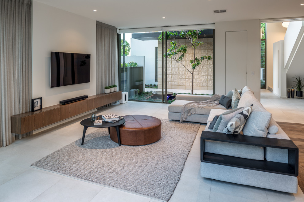 Design ideas for a contemporary open concept living room in Perth with white walls, a wall-mounted tv and grey floor.
