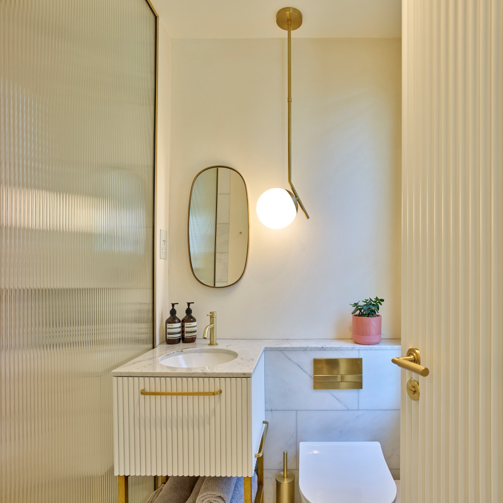 Modern inredning av ett mellanstort vit vitt en-suite badrum, med ett fristående badkar, en kantlös dusch, marmorbänkskiva och med dusch som är öppen