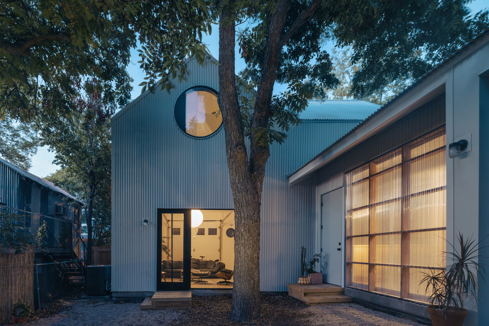 Kleines, Zweistöckiges Modernes Einfamilienhaus mit Metallfassade, Satteldach und Blechdach in Austin