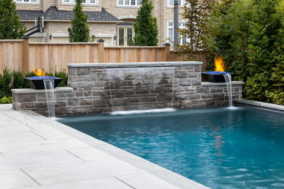 Idee per una piscina chic rettangolare di medie dimensioni e dietro casa con paesaggistica bordo piscina e cemento stampato