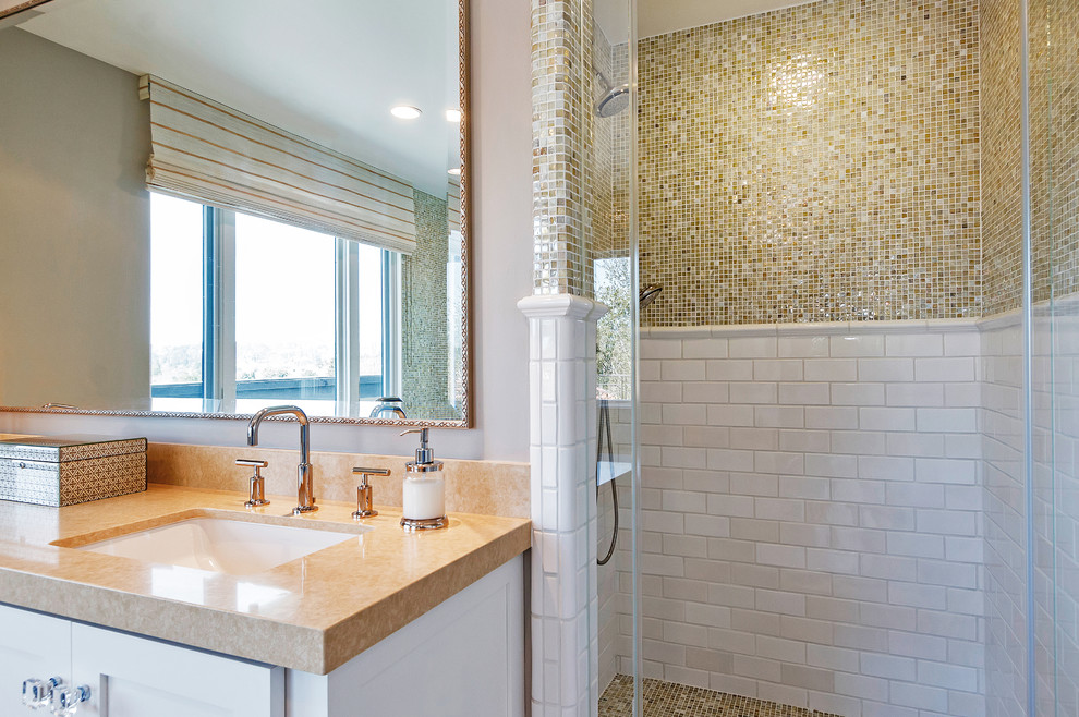 Photo of a transitional master bathroom in San Francisco with an undermount sink, shaker cabinets, white cabinets, engineered quartz benchtops, a drop-in tub, a shower/bathtub combo, a one-piece toilet, white tile, grey walls and porcelain floors.