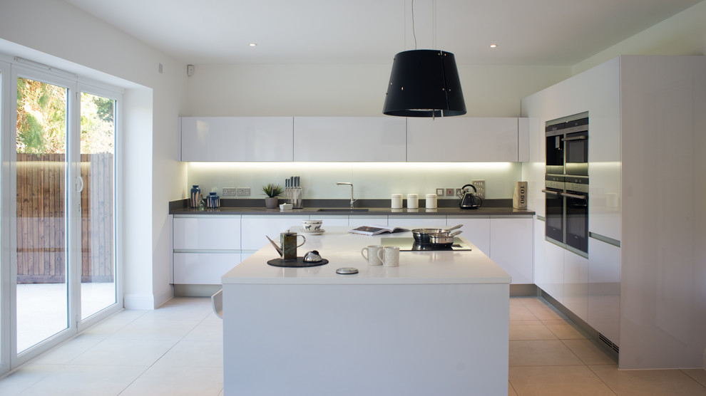 Photo of a large contemporary l-shaped kitchen in Other with an undermount sink, flat-panel cabinets, white cabinets, quartzite benchtops, white splashback, glass tile splashback, stainless steel appliances, porcelain floors and with island.