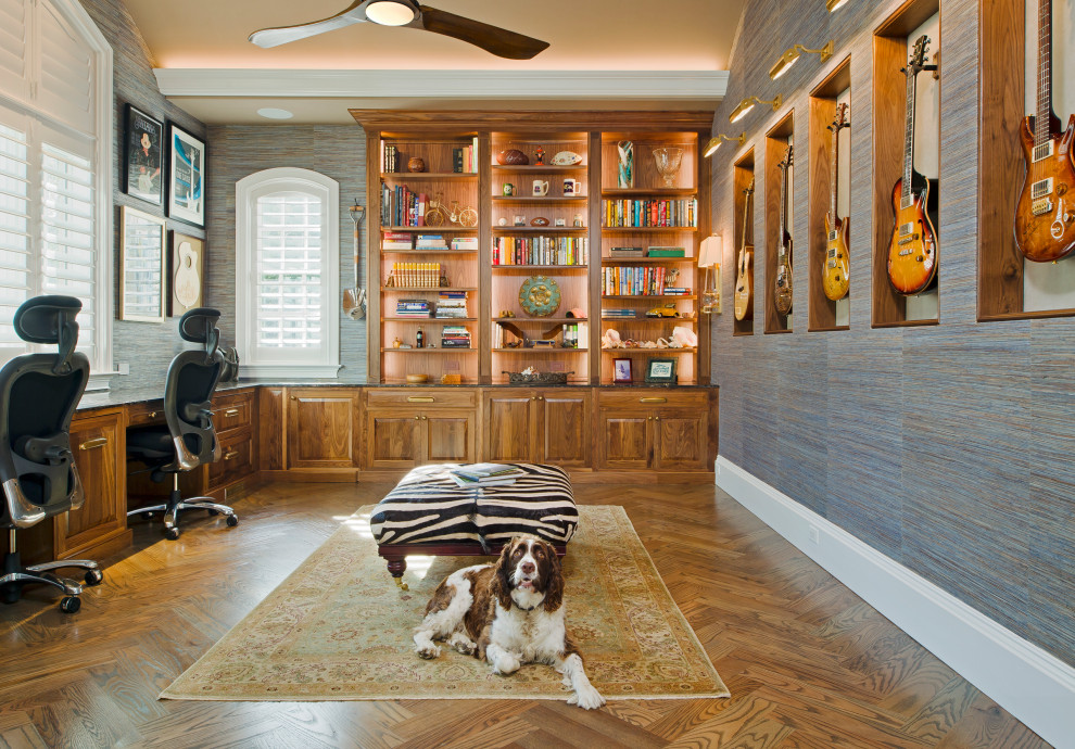 This is an example of a home office in Baltimore with a library, medium hardwood floors, no fireplace, a built-in desk and wallpaper.