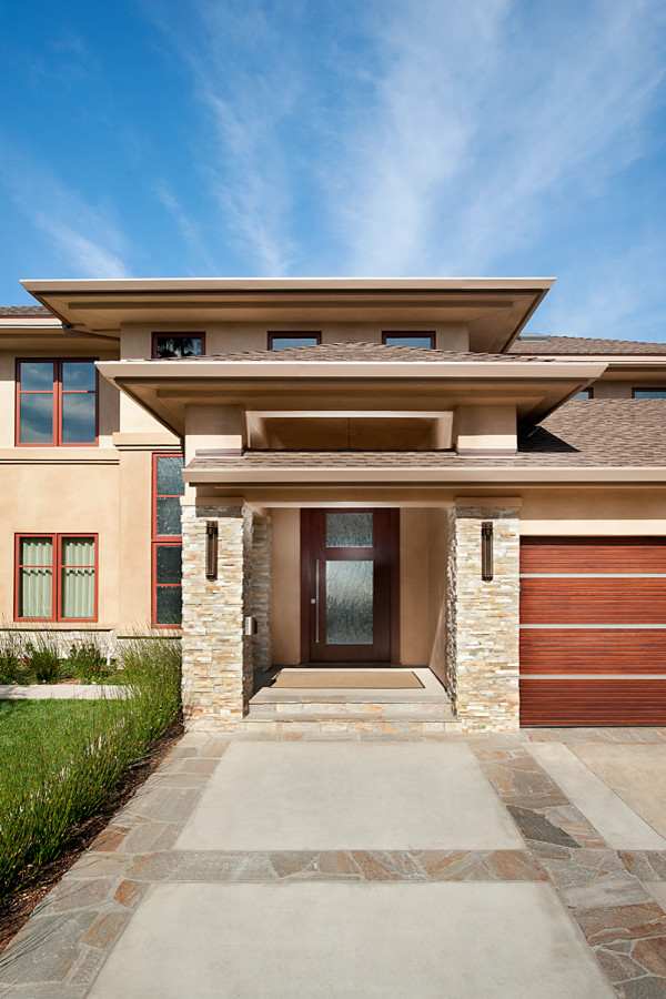 Inspiration for a large contemporary two-storey stucco beige exterior in San Diego with a hip roof.