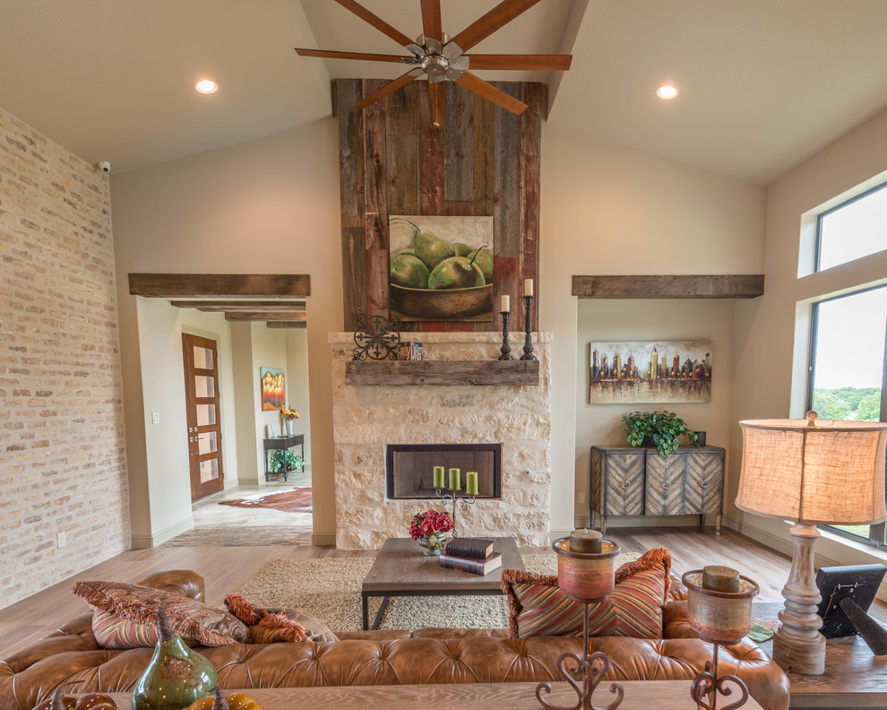 Inspiration for a country open concept living room in Austin with beige walls, light hardwood floors, a stone fireplace surround and a ribbon fireplace.