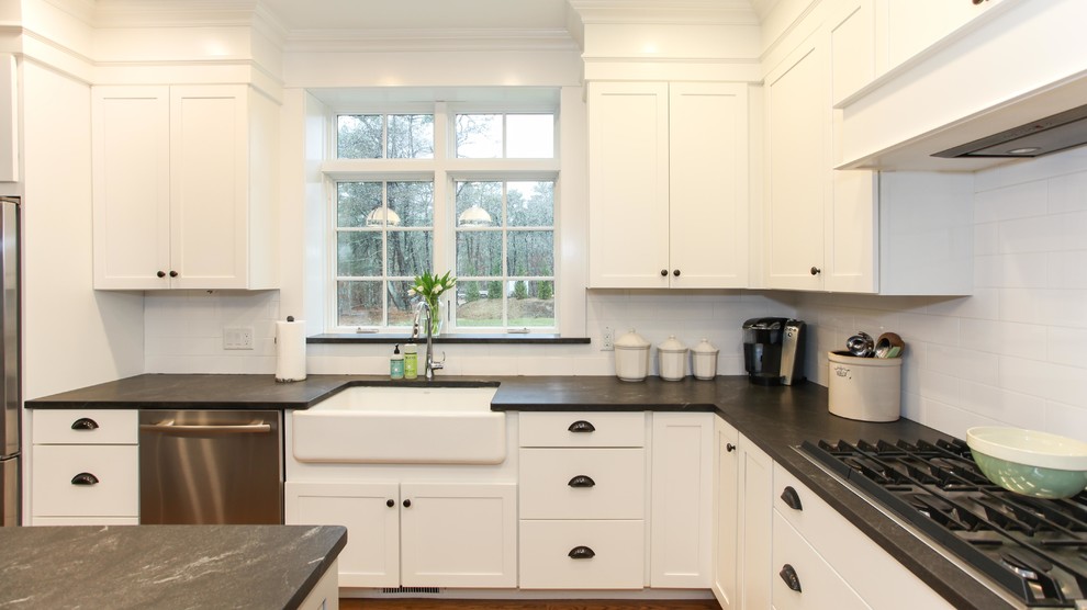 Huge arts and crafts l-shaped medium tone wood floor open concept kitchen photo with a drop-in sink, white cabinets, marble countertops, white backsplash, ceramic backsplash, stainless steel appliances, an island and beaded inset cabinets