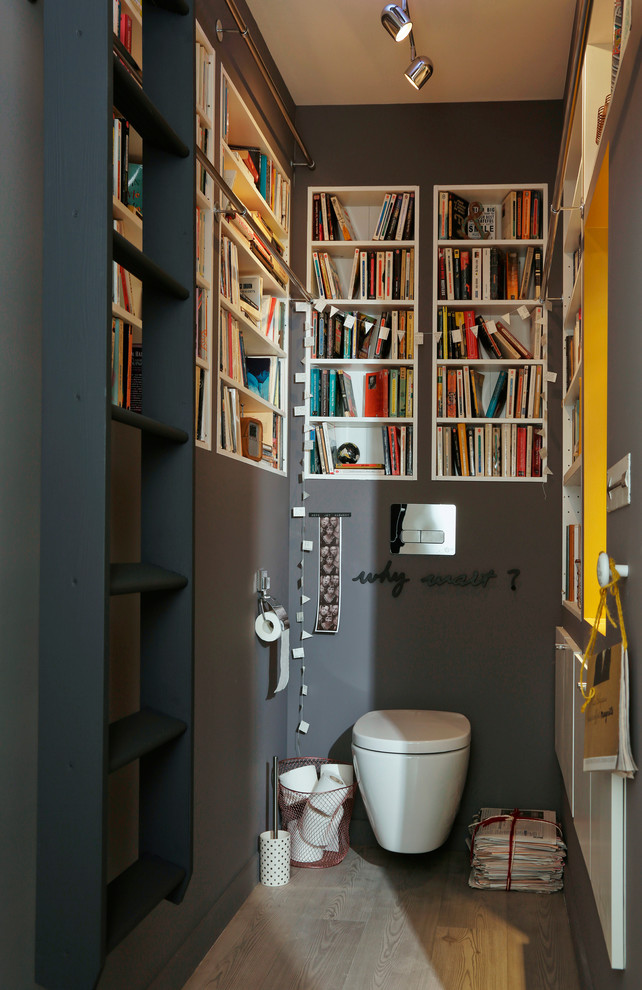 Photo of a mid-sized modern powder room in Lille with a wall-mount toilet and grey walls.