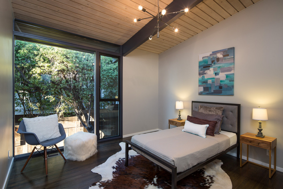 This is an example of a midcentury guest bedroom in San Francisco with grey walls and dark hardwood floors.