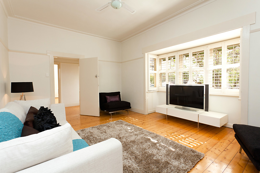 Mid-sized contemporary enclosed living room in Melbourne with beige walls and a freestanding tv.