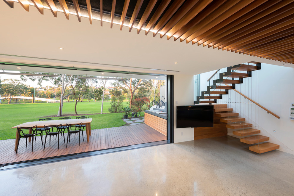 Photo of a large contemporary open concept family room in Melbourne with concrete floors.