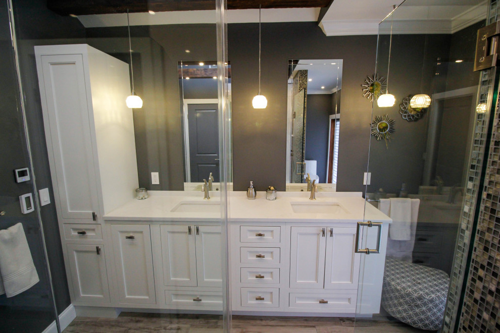 Photo of a large contemporary master bathroom in New York with beaded inset cabinets, white cabinets, an open shower, a two-piece toilet, white tile, porcelain tile, grey walls, porcelain floors, an undermount sink, engineered quartz benchtops, grey floor, a hinged shower door, white benchtops, a double vanity and a built-in vanity.