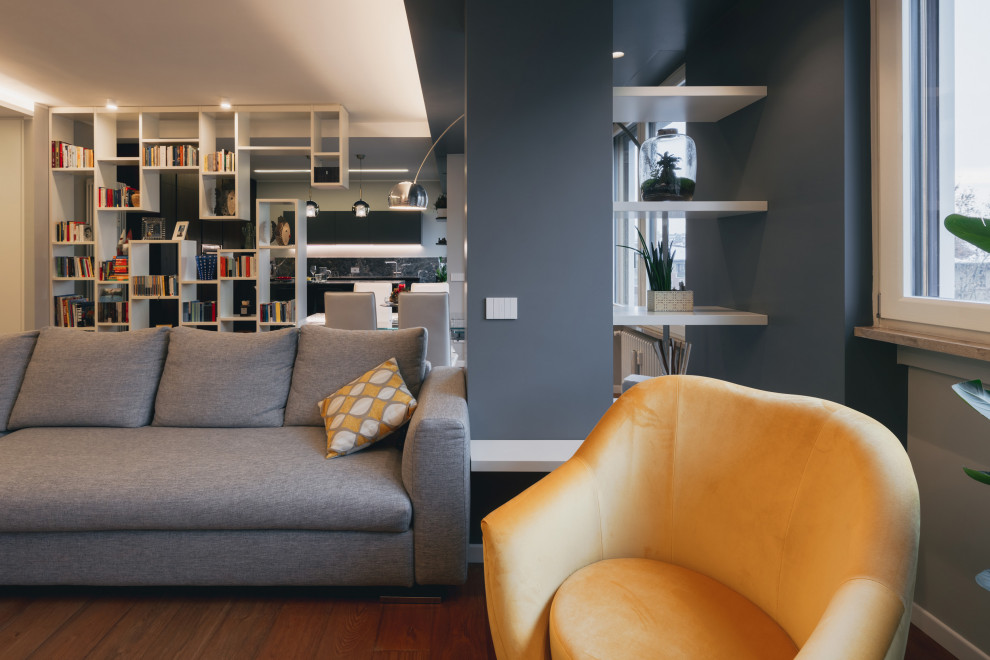 Idée de décoration pour un grand salon design ouvert avec une bibliothèque ou un coin lecture, un mur gris, parquet clair, un téléviseur encastré, un sol marron et un plafond décaissé.