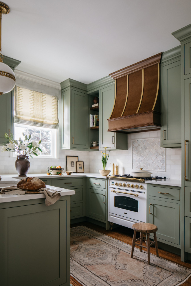 Пример оригинального дизайна: кухня в стиле неоклассика (современная классика) с зелеными фасадами, белым фартуком, фартуком из мрамора и белой столешницей