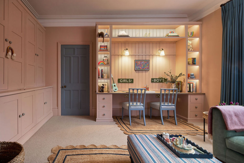 This is an example of a medium sized classic gender neutral kids' bedroom in Kent with pink walls, carpet and beige floors.