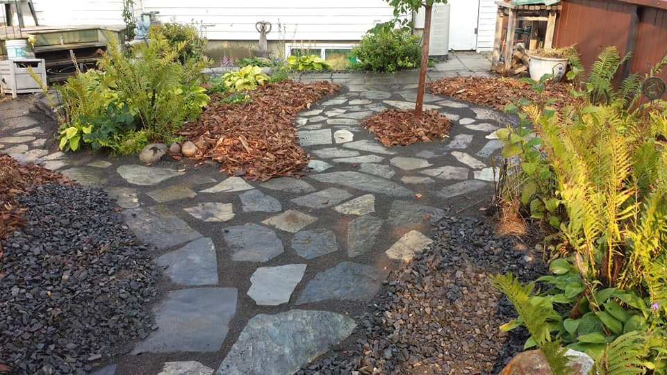 Inspiration for a small country backyard partial sun garden for summer in Edmonton with natural stone pavers.
