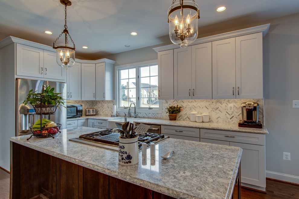 Inspiration for a mid-sized transitional u-shaped dark wood floor and brown floor eat-in kitchen remodel in DC Metro with a farmhouse sink, shaker cabinets, white cabinets, stainless steel appliances, an island, gray countertops, quartzite countertops, white backsplash and mosaic tile backsplash