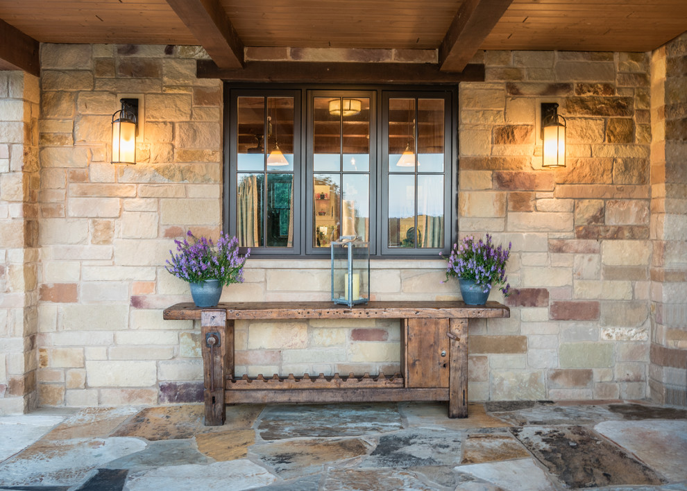 Photo of an expansive contemporary courtyard patio in Austin with an outdoor kitchen, natural stone pavers and a pergola.