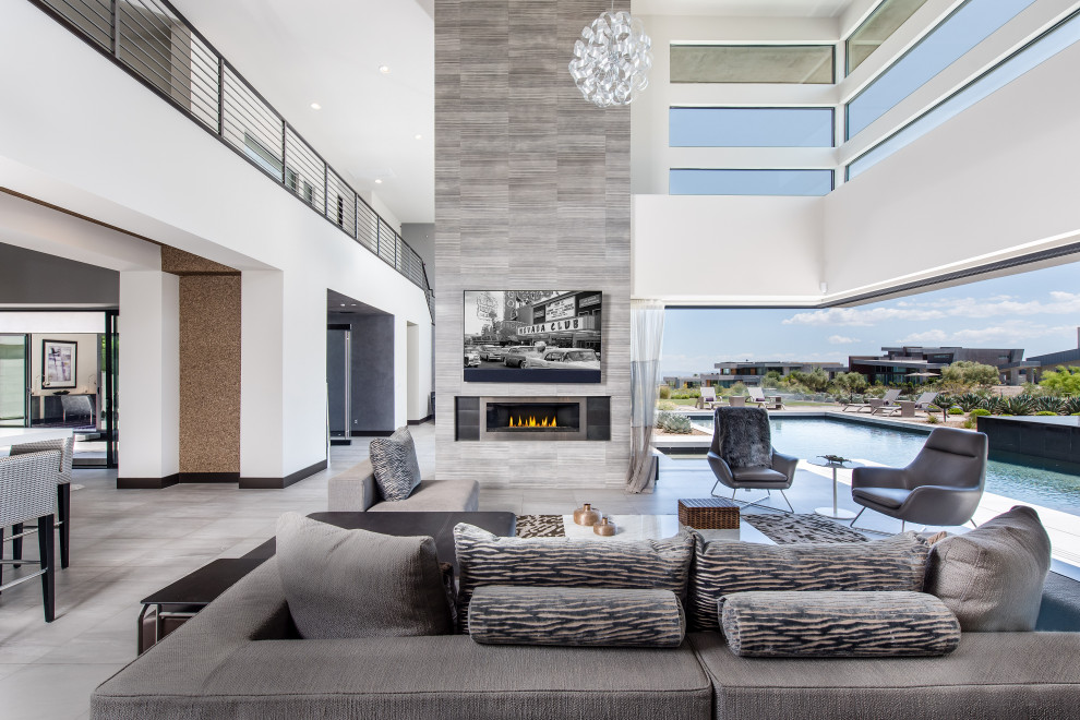 Large contemporary open concept living room in Las Vegas with white walls, a ribbon fireplace, a wall-mounted tv and grey floor.