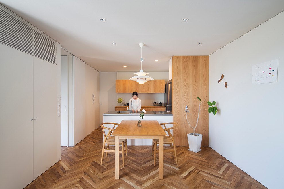 Inspiration for a scandinavian u-shaped eat-in kitchen in Kobe with flat-panel cabinets, light wood cabinets, light hardwood floors and a peninsula.