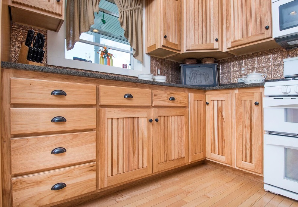 Inspiration for a mid-sized rustic u-shaped light wood floor and brown floor eat-in kitchen remodel in Cincinnati with a farmhouse sink, recessed-panel cabinets, light wood cabinets, granite countertops, metallic backsplash, ceramic backsplash, white appliances, a peninsula and gray countertops