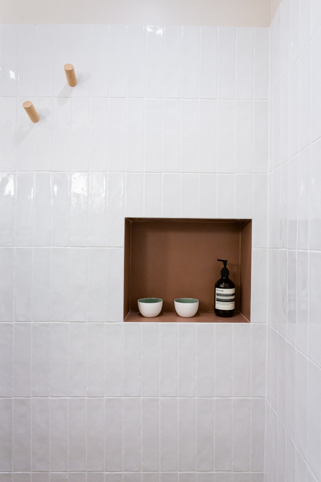 Свежая идея для дизайна: маленькая ванная комната в белых тонах с отделкой деревом в классическом стиле с фасадами с утопленной филенкой, светлыми деревянными фасадами, душем без бортиков, белой плиткой, керамогранитной плиткой, розовыми стенами, полом из керамической плитки, душевой кабиной, консольной раковиной, столешницей из искусственного камня, оранжевым полом, открытым душем, белой столешницей, нишей, тумбой под одну раковину и подвесной тумбой для на участке и в саду - отличное фото интерьера