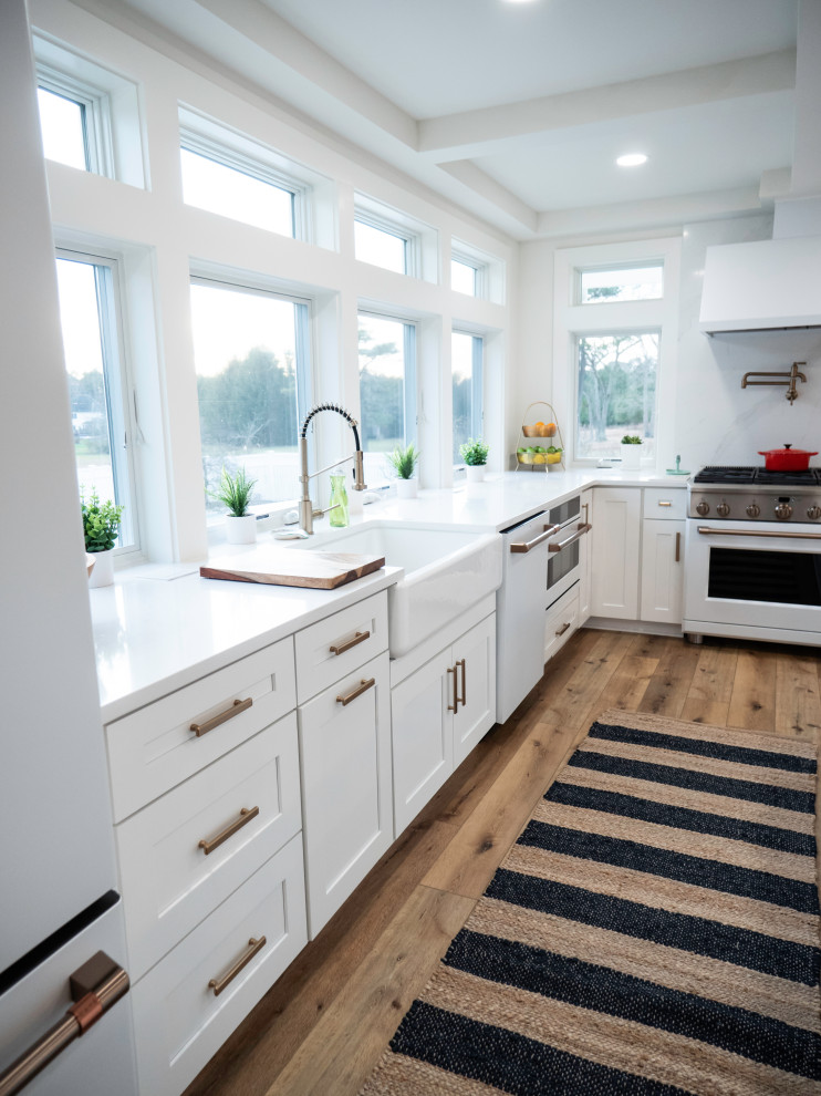 Exempel på ett mycket stort modernt vit vitt kök med öppen planlösning, med en rustik diskho, skåp i shakerstil, vita skåp, träbänkskiva, vitt stänkskydd, vita vitvaror, laminatgolv, flera köksöar och brunt golv