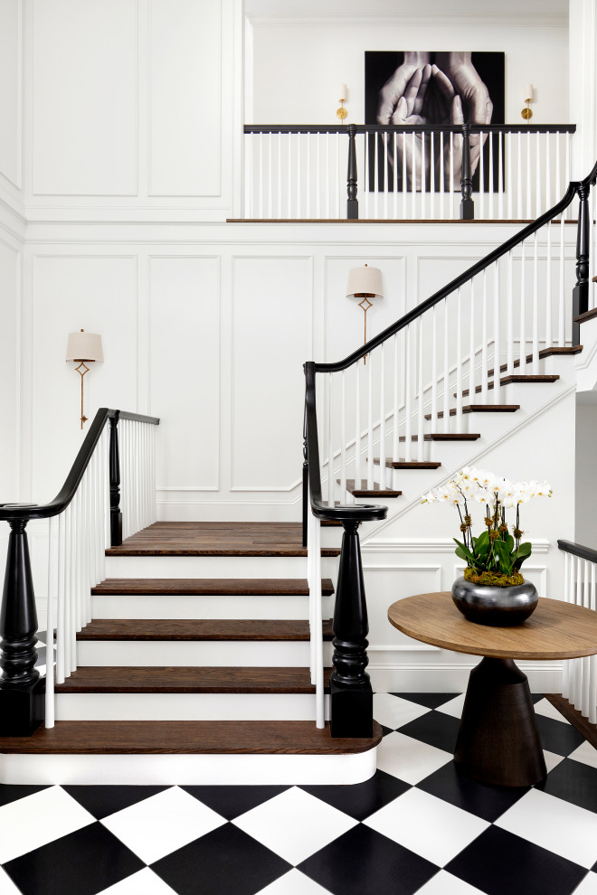 Стильный дизайн: большая п-образная лестница в стиле фьюжн с деревянными ступенями, крашенными деревянными подступенками, деревянными перилами и панелями на стенах - последний тренд