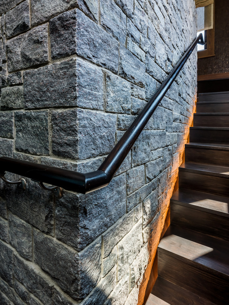 Custom staircase disappears behind the central fireplace, featuring LED lighting - Elizabeth Pedinotti Haynes