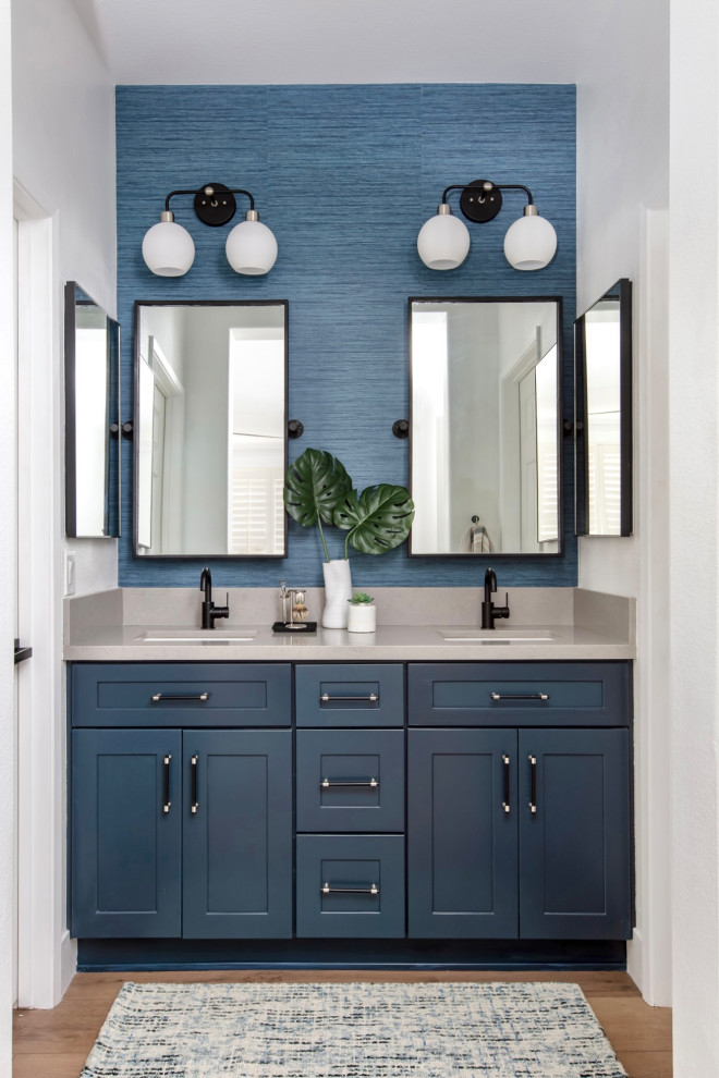 Inspiration for a small modern ensuite bathroom in San Diego with shaker cabinets, blue cabinets, laminate floors, a submerged sink, engineered stone worktops, blue floors, beige worktops, double sinks, a built in vanity unit and wallpapered walls.